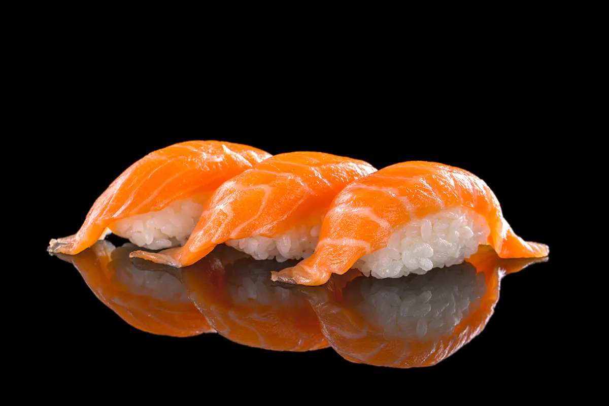 Fresh salmon nigiri sushi pieces on a black background at LA Sushi And Hibachi, a Japanese Restaurant in Santa Fe